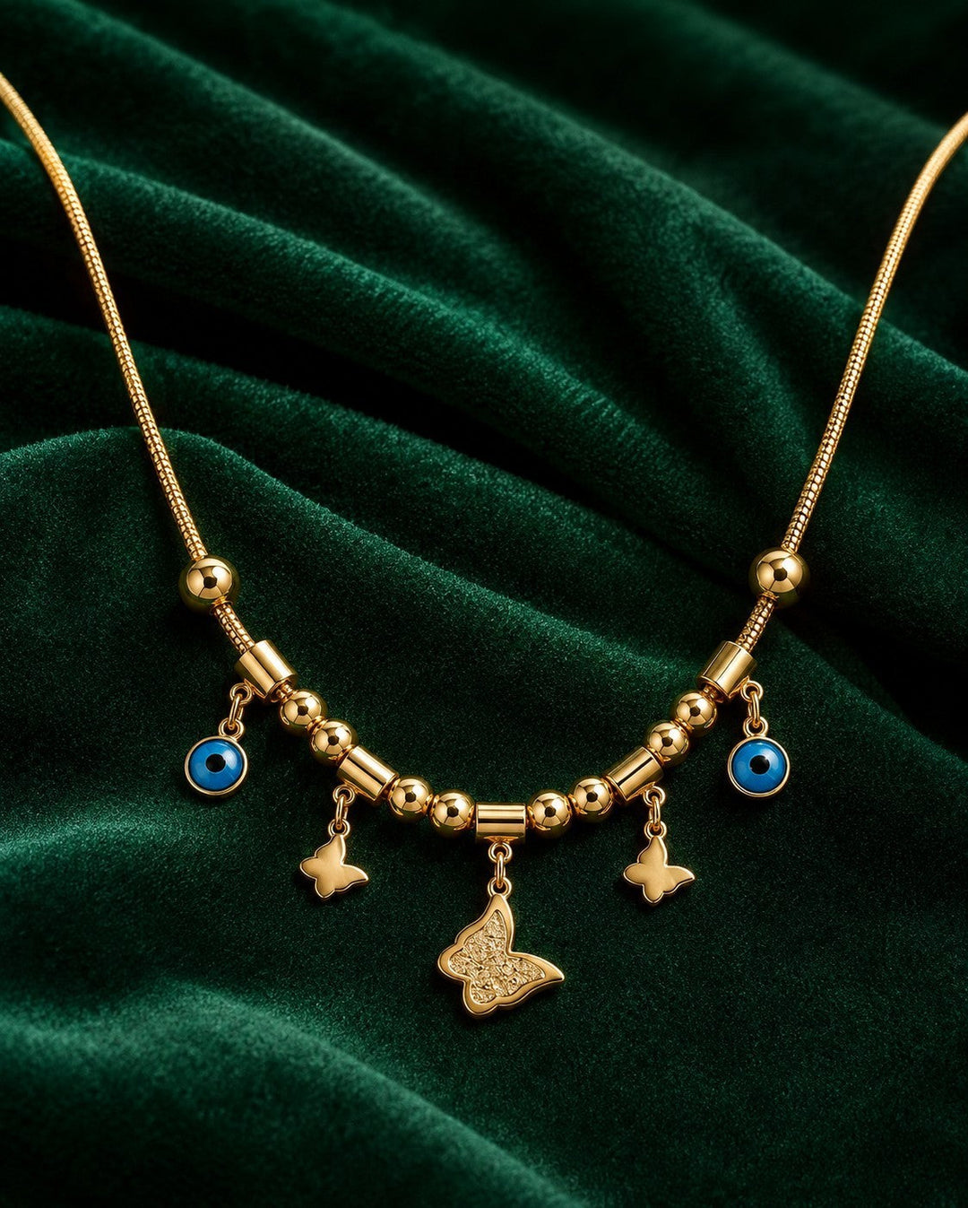 Elli Jewellery gold plated necklace featuring butterfly charms and blue evil eye pendants on a fine mesh chain.