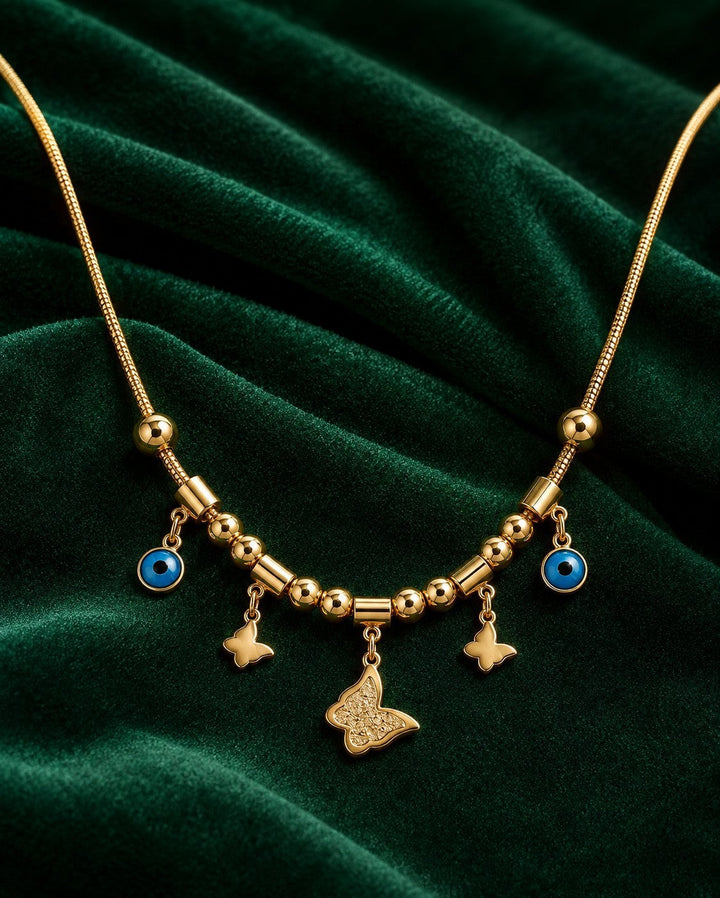 Elli Jewellery gold plated necklace featuring butterfly charms and blue evil eye pendants on a fine mesh chain.