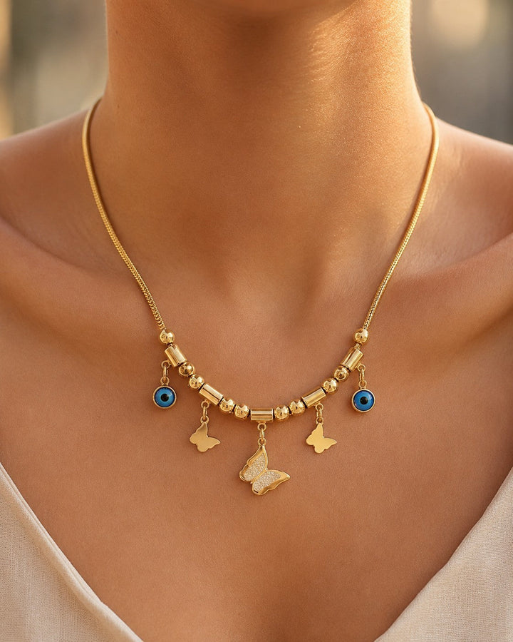 Elli Jewellery gold plated necklace featuring butterfly charms and blue evil eye pendants on a fine mesh chain
