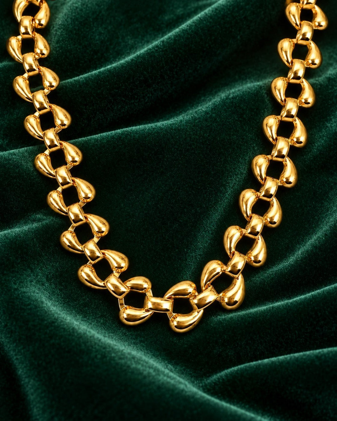 Elli Jewellery chunky curb chain necklace in 18ct gold plated metal with high-shine rounded links on green velvet