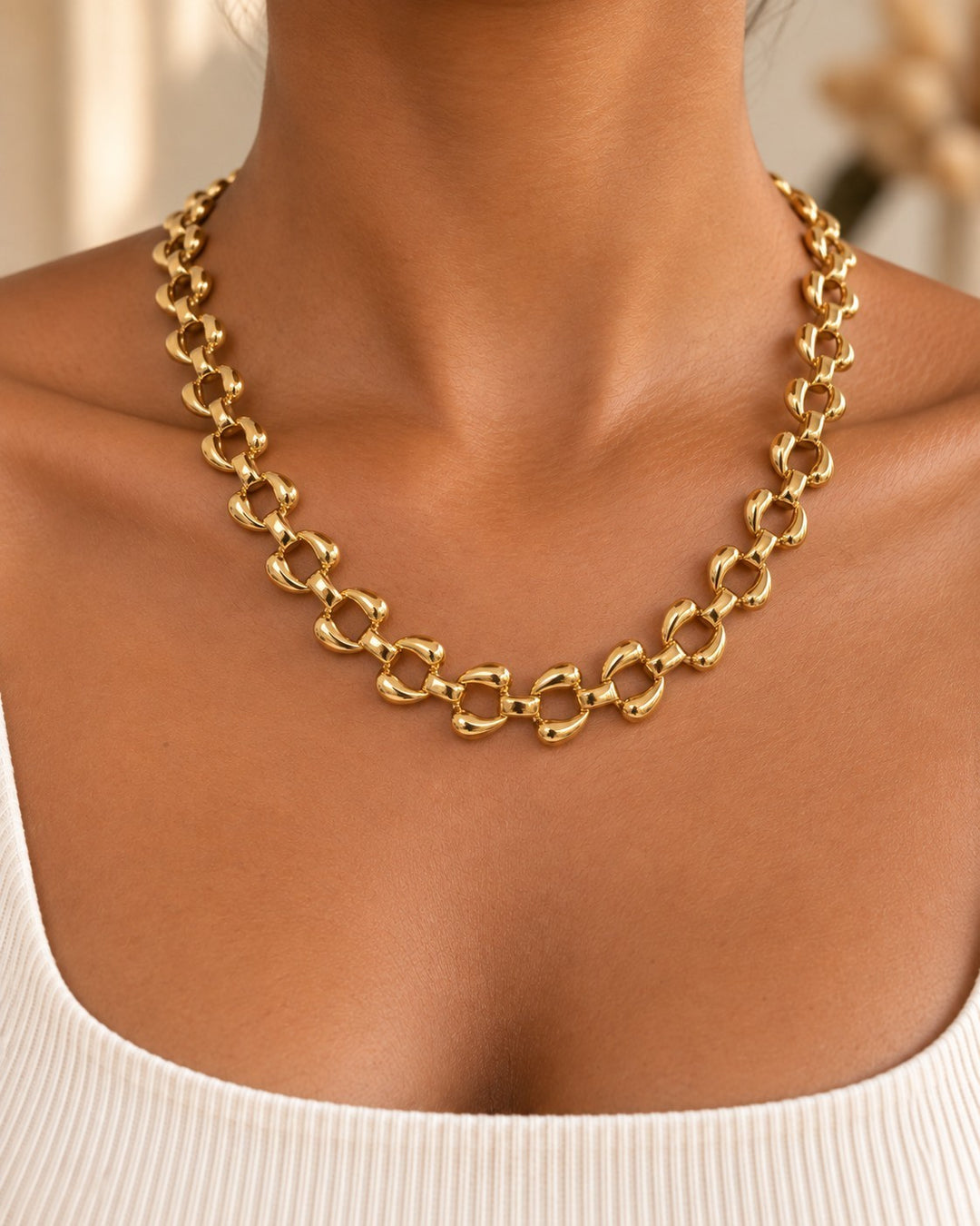 Elli Jewellery chunky gold plated curb chain necklace worn on a model, featuring polished rounded links.