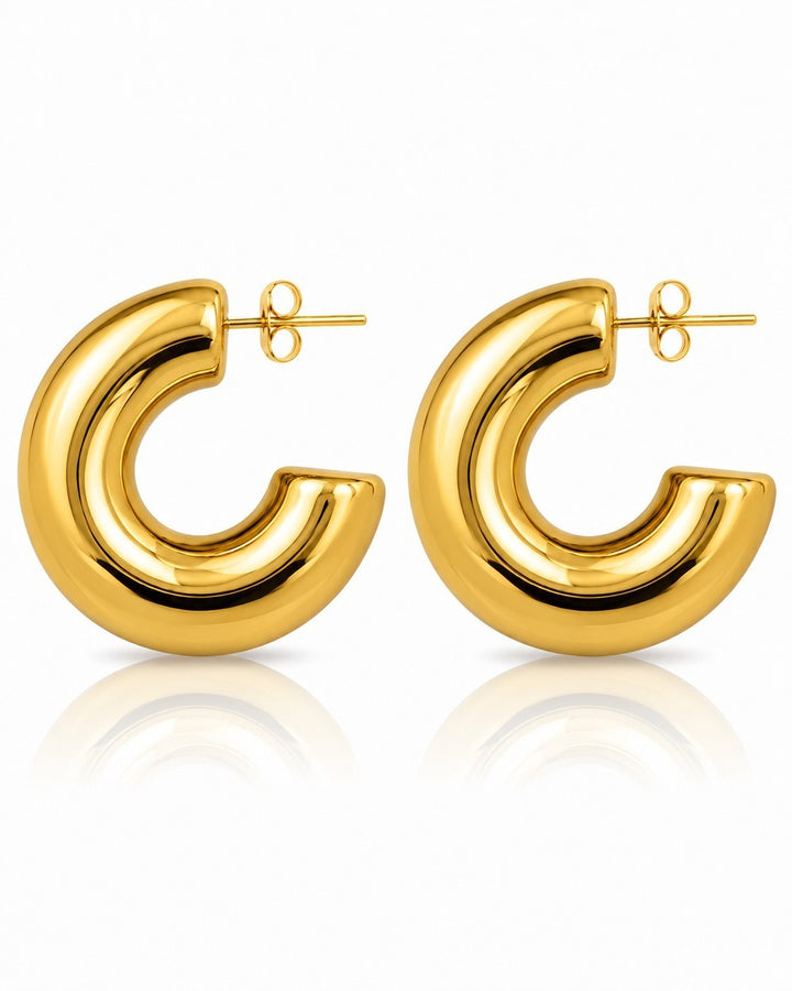 Elli Jewellery chunky C-shaped hoop earrings in polished gold-plated metal on a white background.