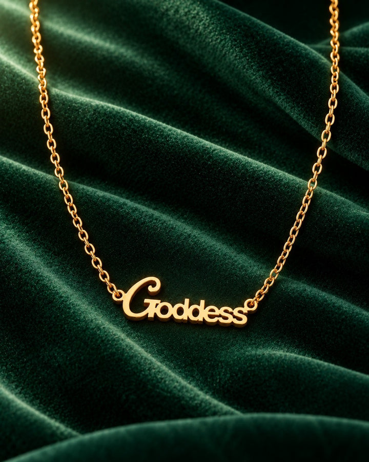 Elli Jewellery gold plated Goddess pendant necklace on a dark green velvet background