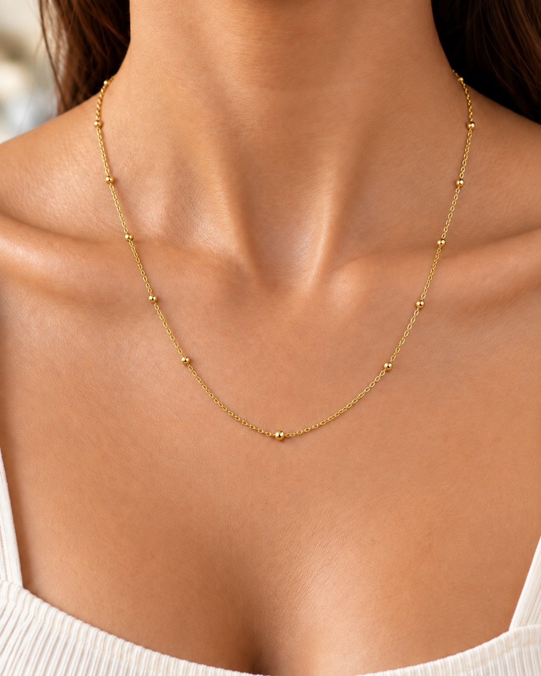 Elli Jewellery gold plated dainty ball bead chain necklace worn on a model, featuring a delicate minimalist design.