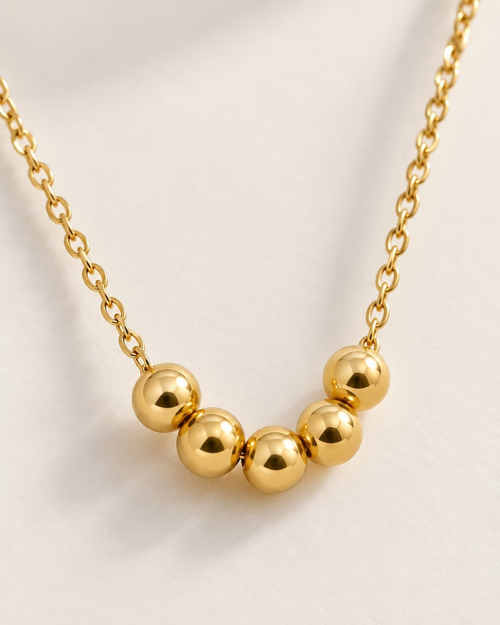 Elli Jewellery gold plated waterproof necklace featuring five polished spherical ball charms on a delicate chain.