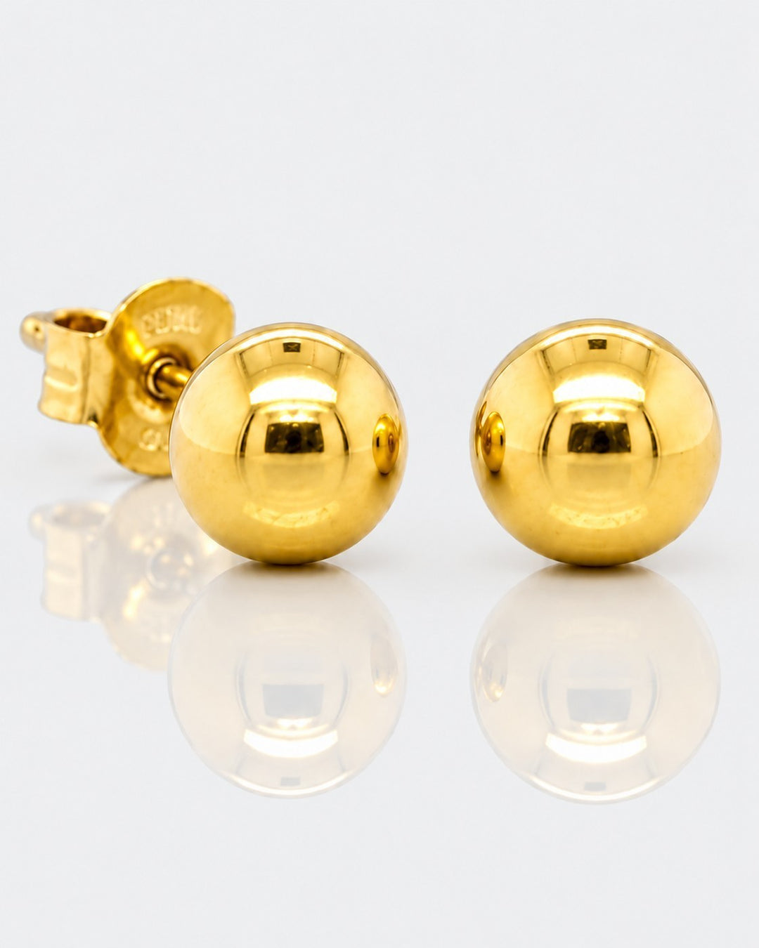 Elli Jewellery gold plated minimalist ball stud earrings with a polished finish on a reflective white surface.