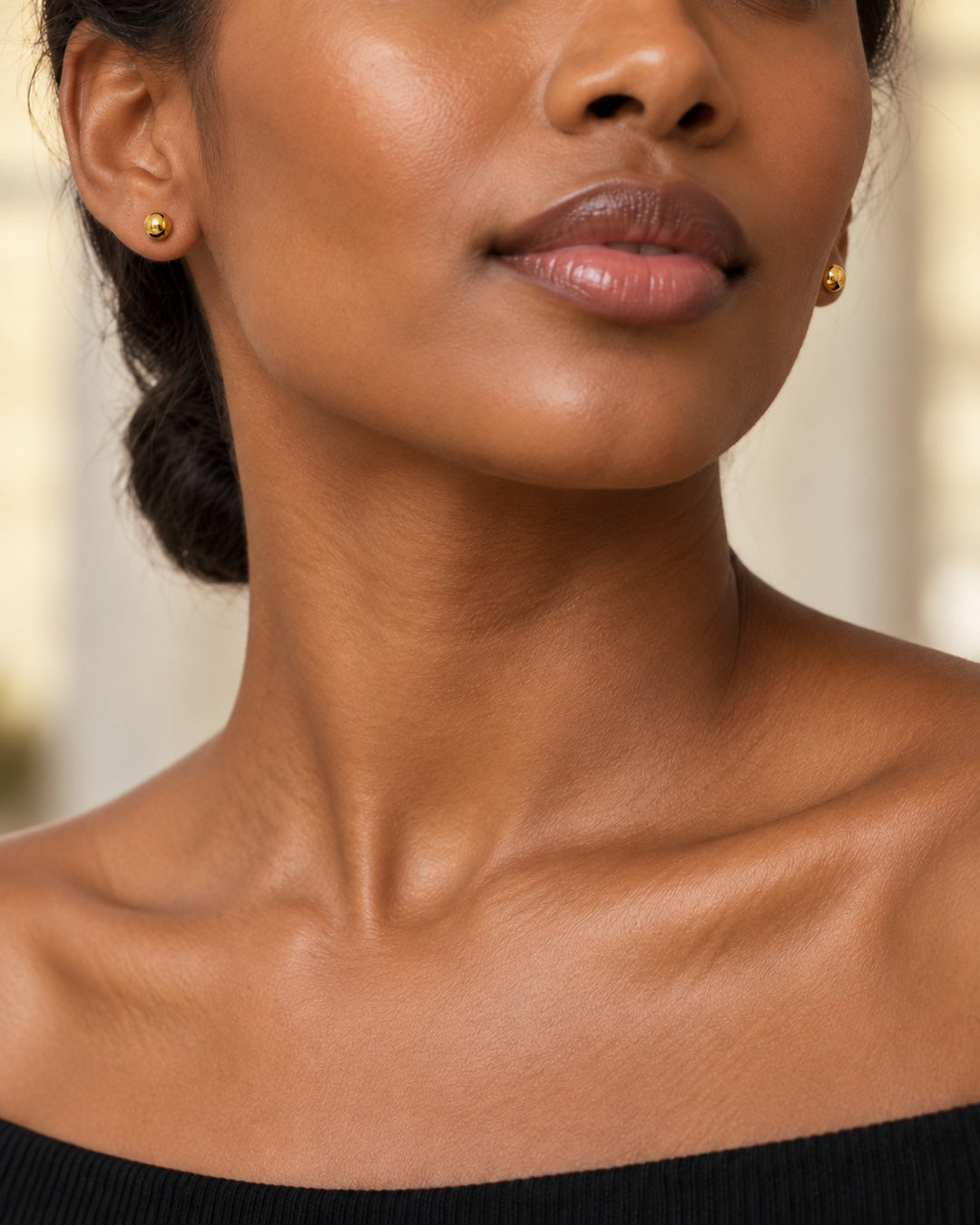 Elli Jewellery minimalist gold plated small ball stud earrings worn by a woman with a natural, elegant look.
