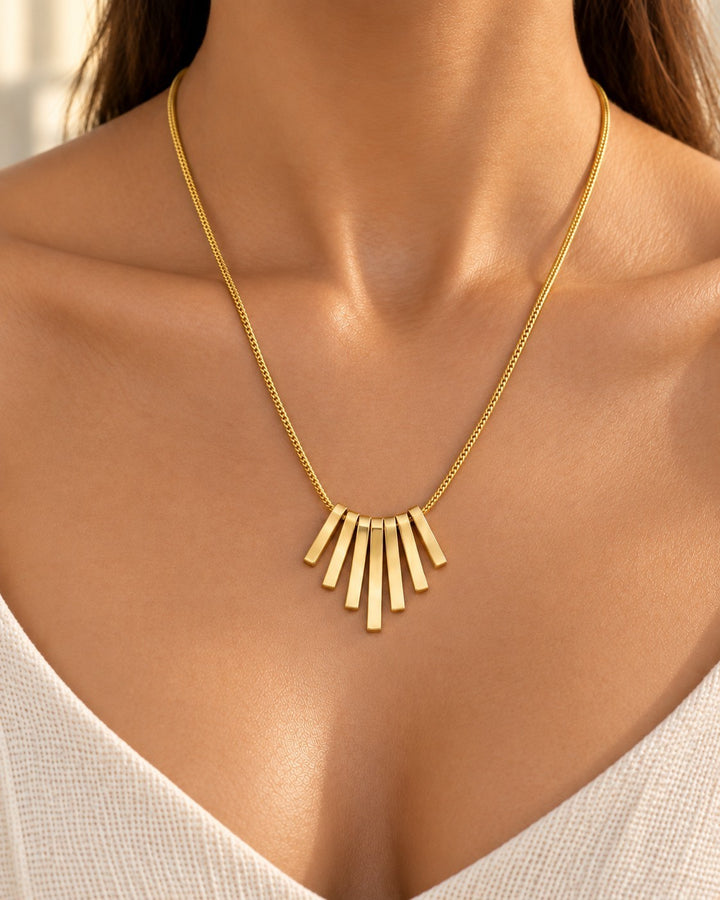 Elli Jewellery gold plated necklace featuring a minimalist fan-shaped pendant with vertical bars on a delicate chain.