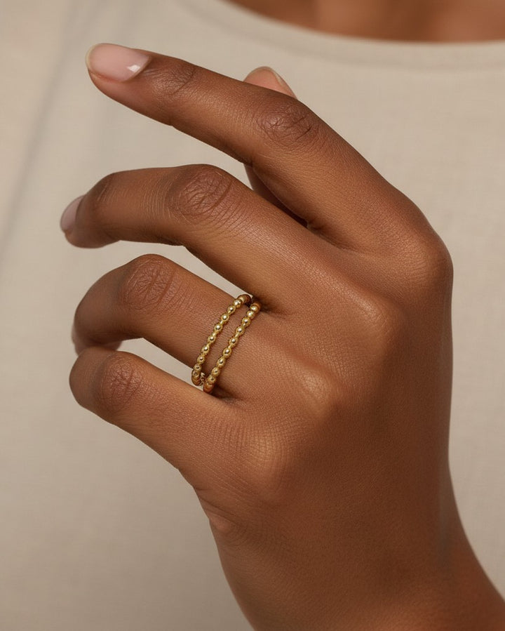 Elli Jewellery gold plated double stack ring with a delicate beaded texture worn on a finger.