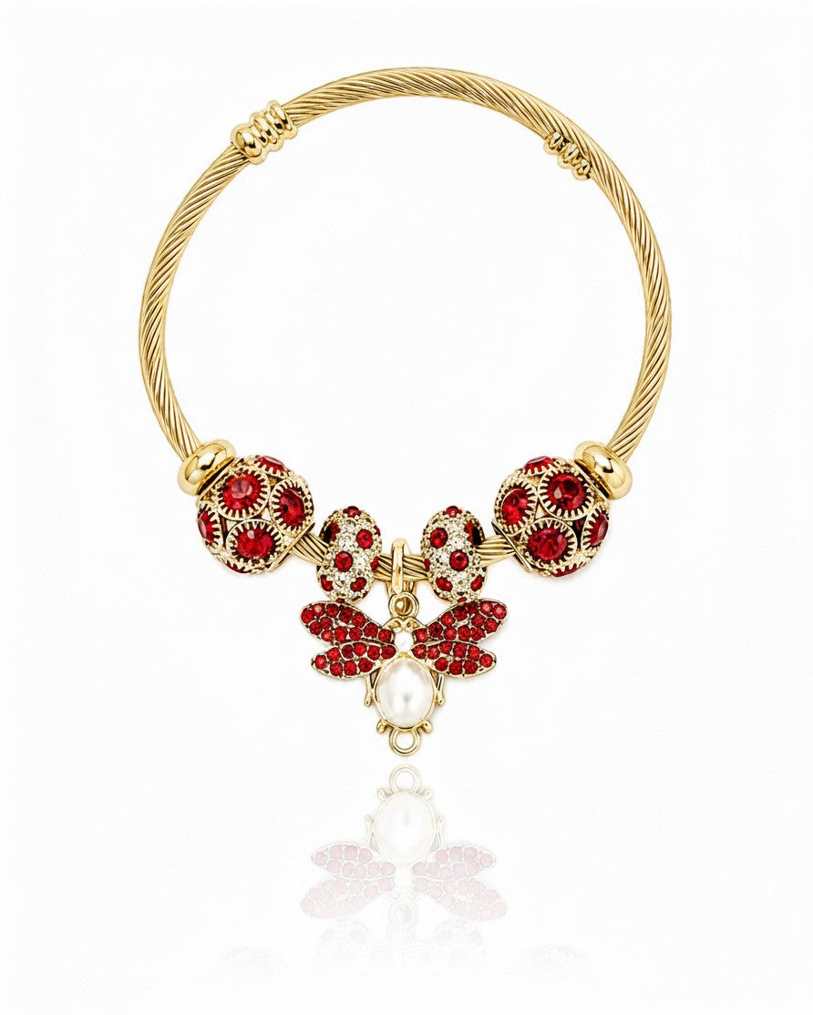 Elli Jewellery gold plated hinged bangle featuring a bee charm with red crystals and a central pearl accent