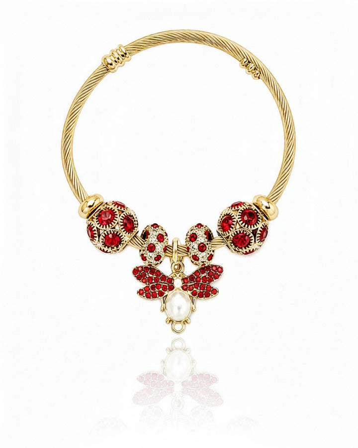Elli Jewellery gold plated hinged bangle featuring a bee charm with red crystals and a central pearl accent