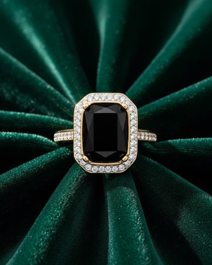 Elli Jewellery gold plated ring featuring a rectangular black stone surrounded by a halo of crystals on green velvet