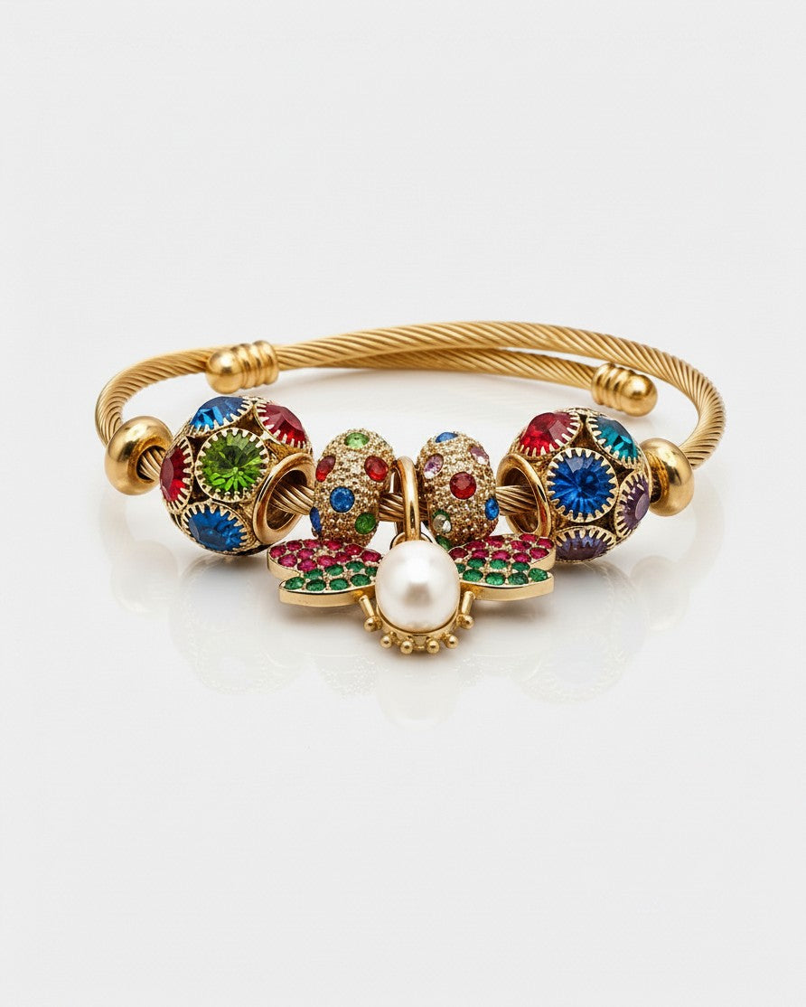 Elli Jewellery gold plated bangle featuring a butterfly charm with red and green enamel, pearl, and crystal beads.