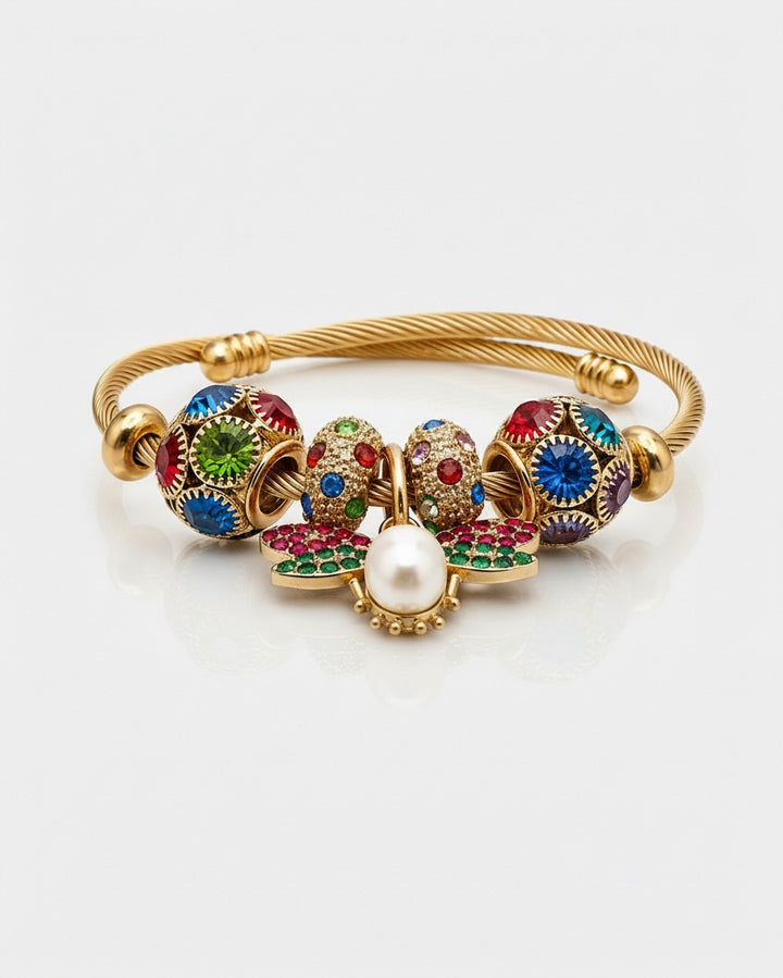 Elli Jewellery gold plated bangle featuring a butterfly charm with red and green enamel, pearl, and crystal beads.
