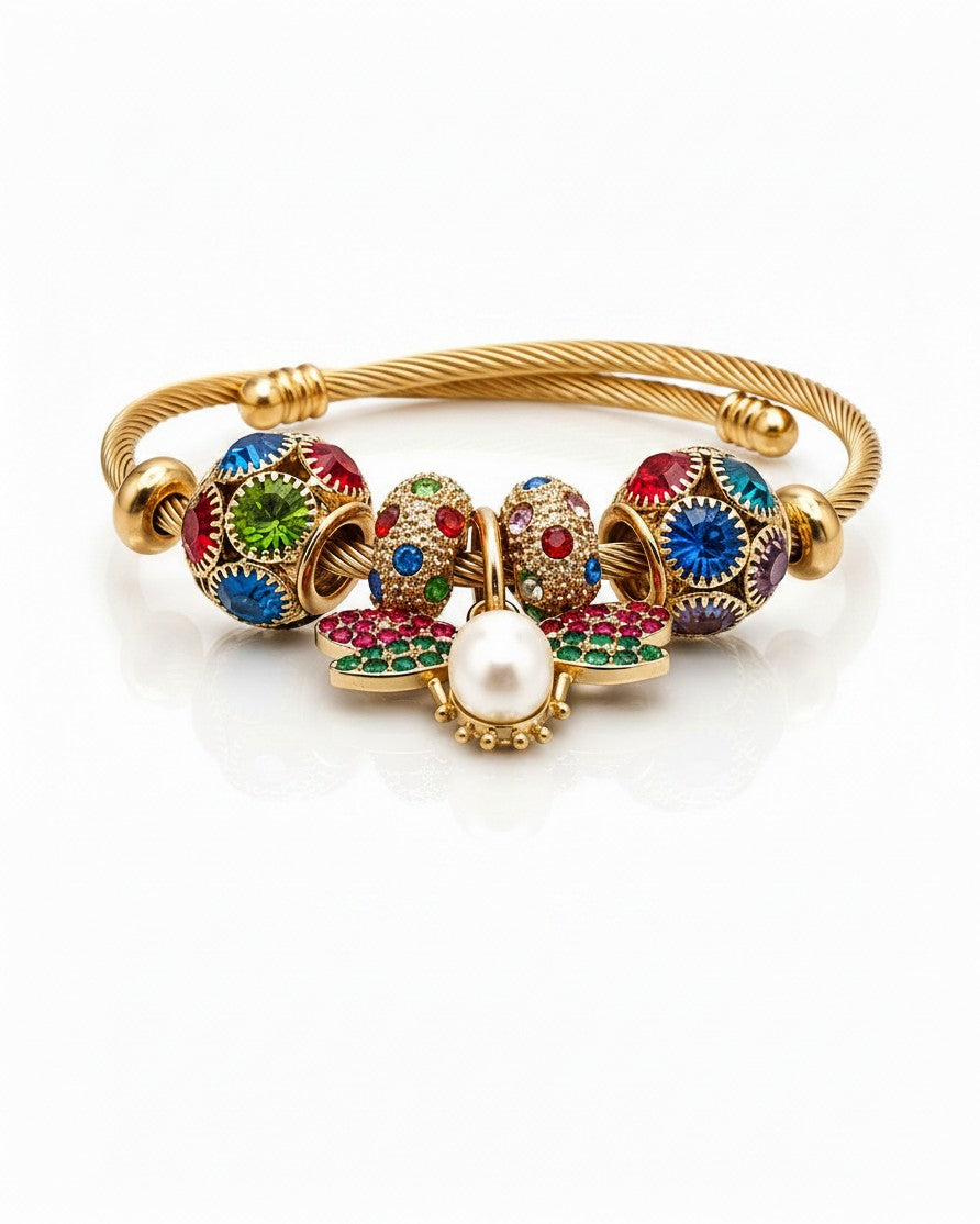 Elli Jewellery gold plated bangle featuring a butterfly charm with red and green enamel, pearl, and colourful crystals.