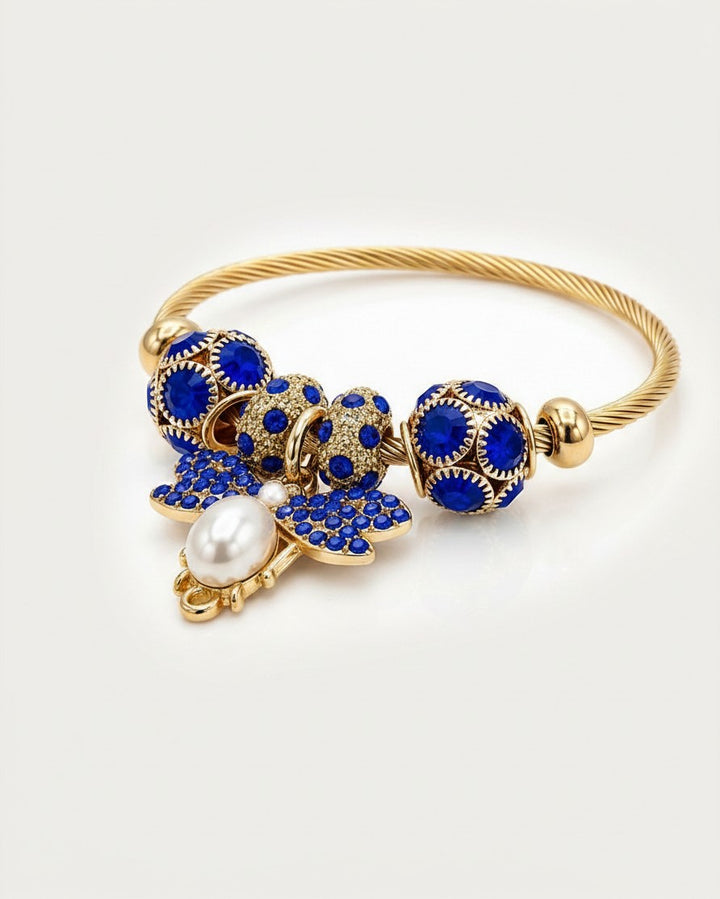 Elli Jewellery gold plated adjustable bangle featuring a blue enamel butterfly charm, pearl accent, and crystal beads.