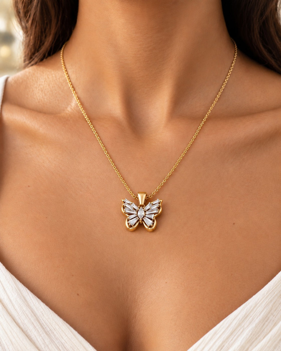 Elli Jewellery gold plated butterfly pendant necklace with sparkling cubic zirconia stones worn on a delicate chain
