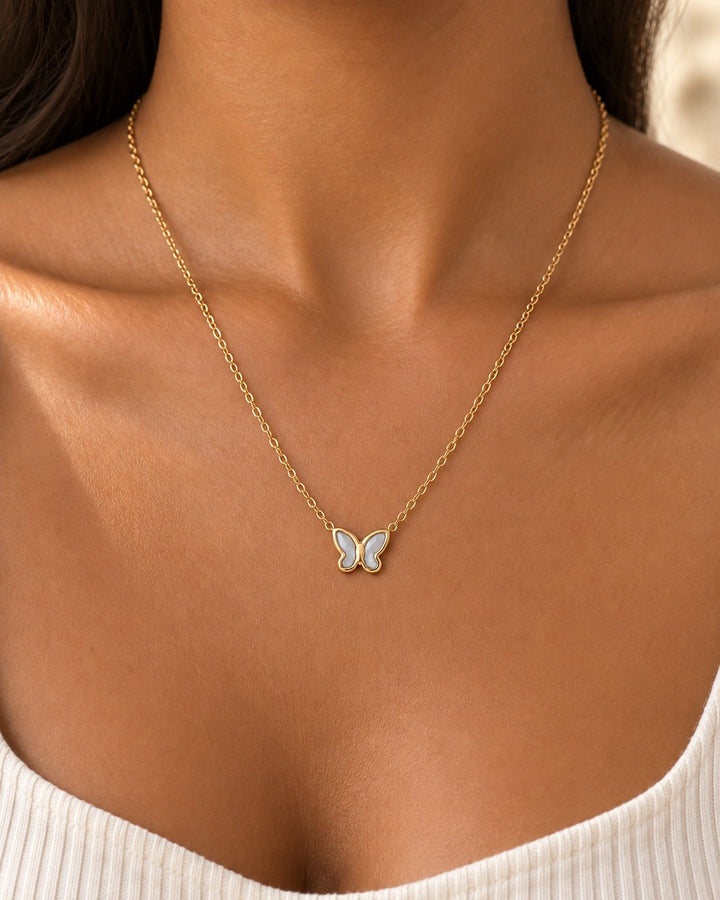 Elli Jewellery gold plated butterfly pendant necklace with mother of pearl inlay worn on a model