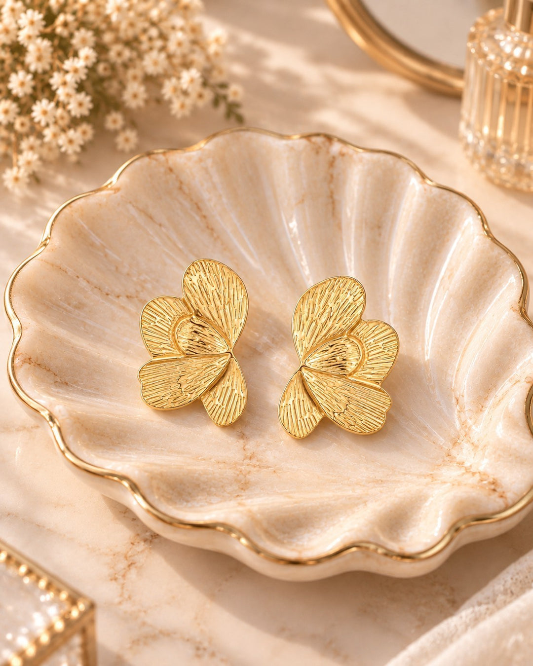 Elli Jewellery sculptural butterfly stud earrings in 18ct gold plated metal with fine etched linear texture.