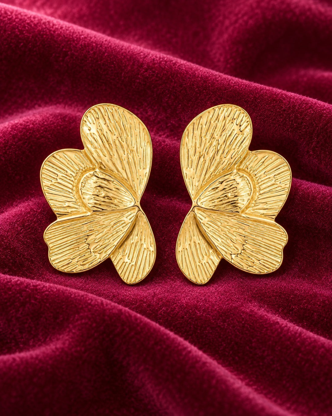 Elli Jewellery sculptural butterfly stud earrings in 18ct gold plated metal with etched linear texture on velvet