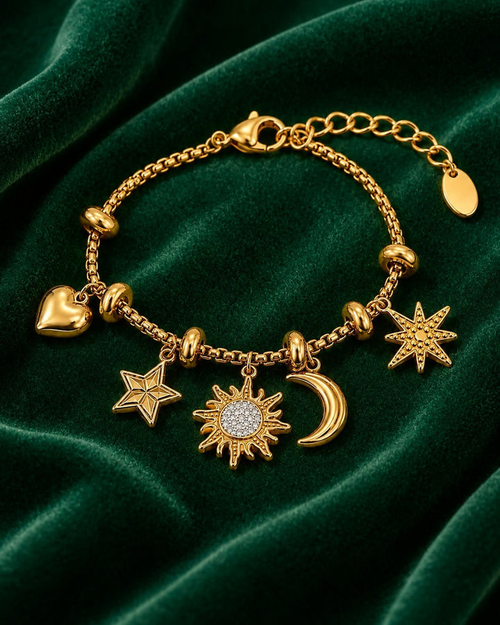 Elli Jewellery gold plated charm bracelet featuring sun, moon, star, and heart pendants on a green velvet background.