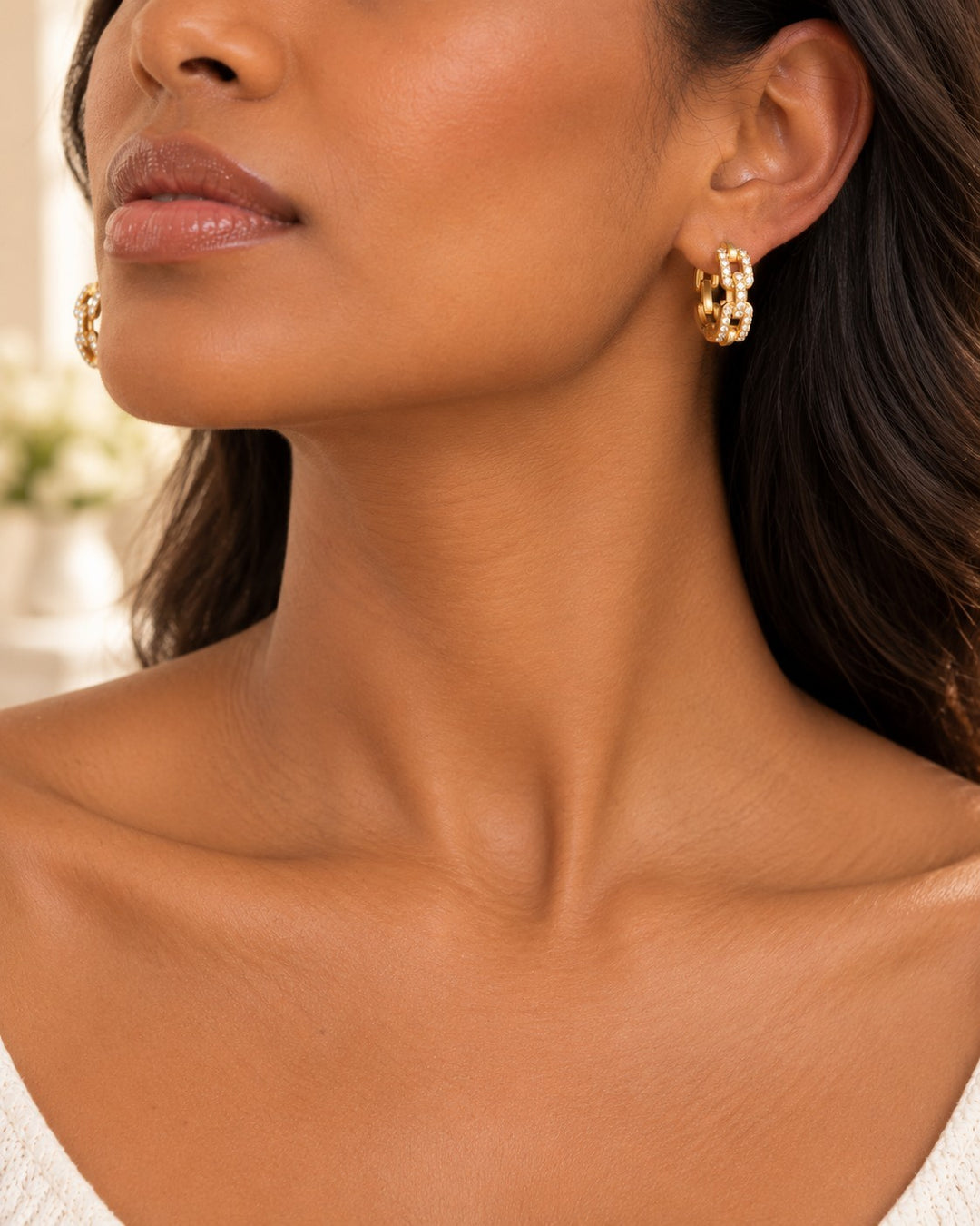Elli Jewellery gold plated chunky chain link drop earrings worn by a woman with dark hair