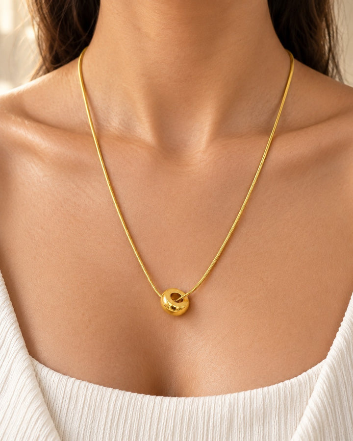 Elli Jewellery gold plated waterproof chain necklace with a minimalist round pendant worn on a model
