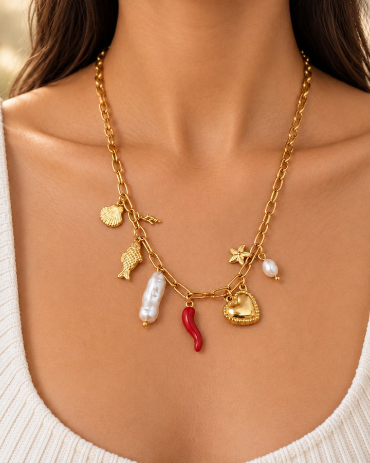 Elli Jewellery gold-plated charm necklace featuring a heart, pearl, seashell, fish, and red chili pendant on a chain
