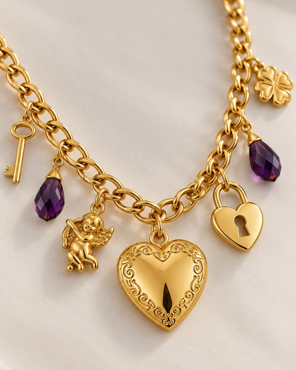 Elli Jewellery gold plated charm necklace featuring a heart locket, purple crystals, key, cupid, and clover charms.