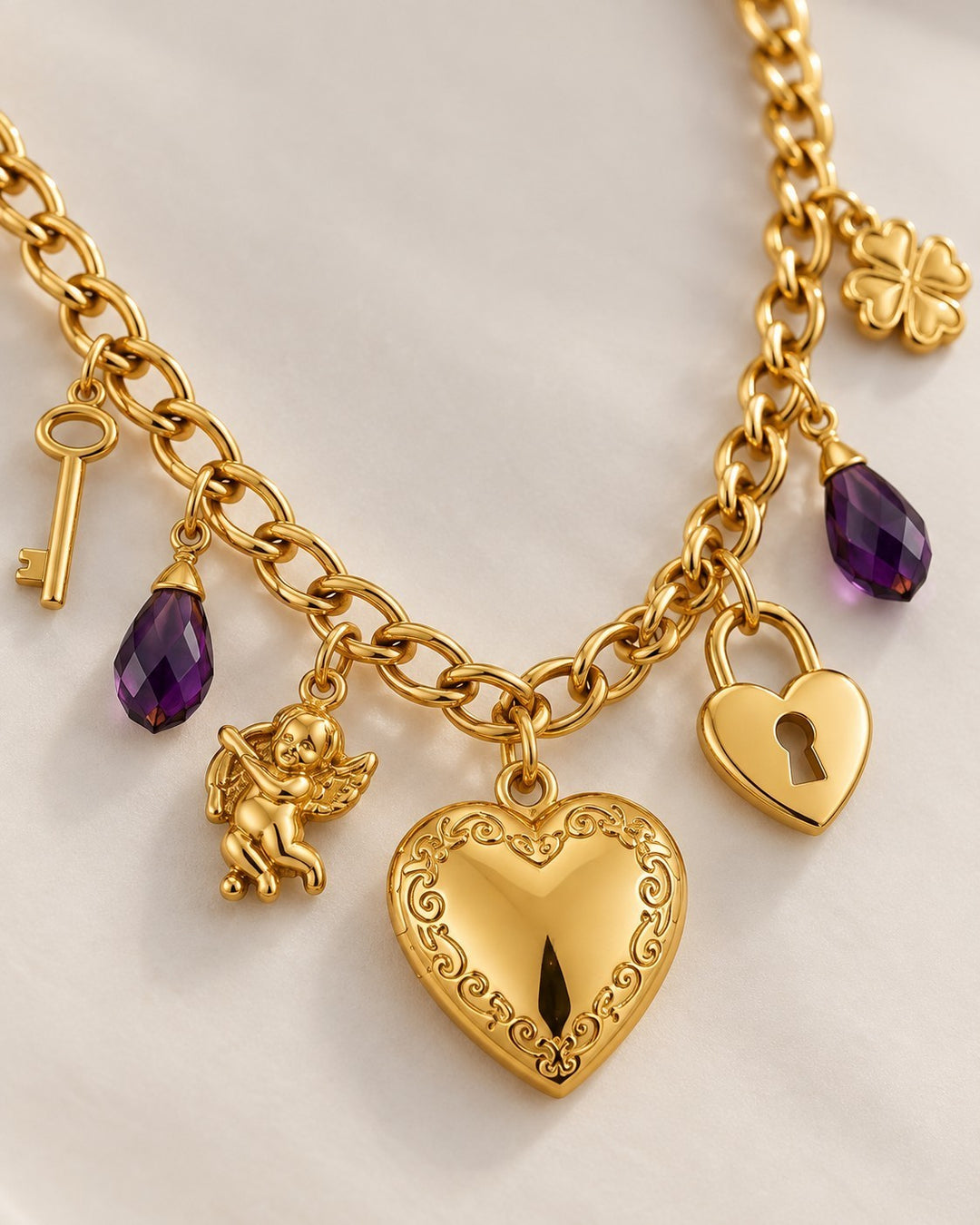 Elli Jewellery gold plated charm necklace featuring a heart locket, purple crystals, key, cupid, and clover charms.