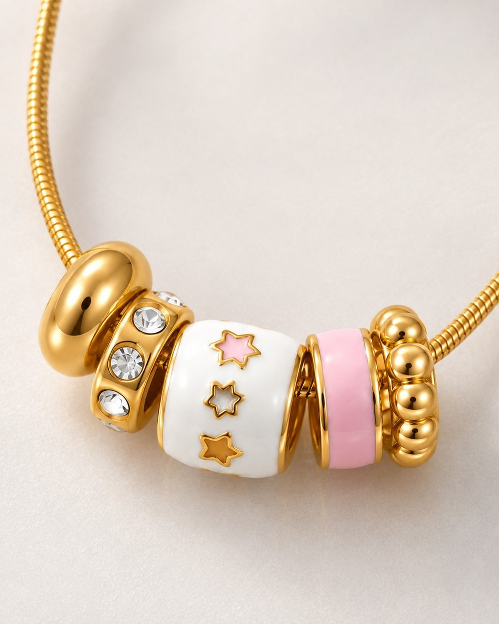Elli Jewellery gold plated dainty necklace featuring white and pink enamel star charms and sparkling crystal accents.