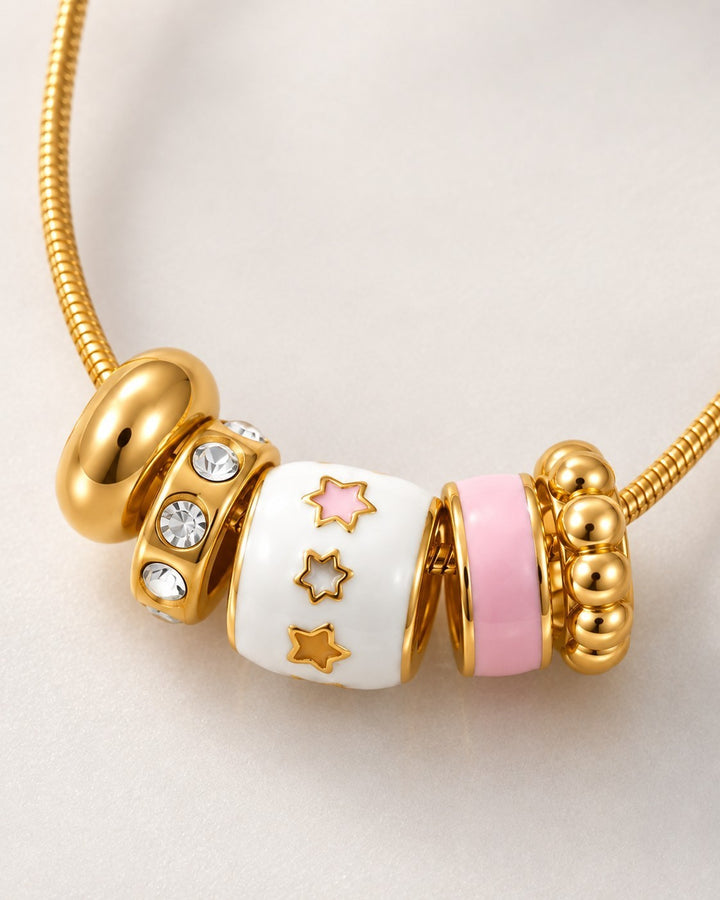 Elli Jewellery gold plated dainty necklace featuring white and pink enamel star charms and sparkling crystal accents.