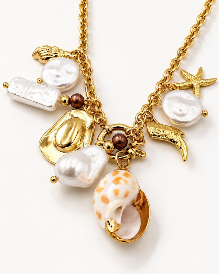 Elli Jewellery gold plated statement necklace featuring assorted pearl, shell, and cowboy hat charms on a link chain.
