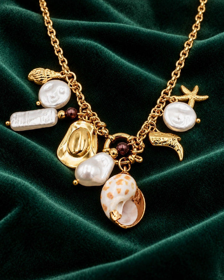 Elli Jewellery gold plated multi-charm necklace featuring baroque pearls, seashells, and cowboy boot charms.