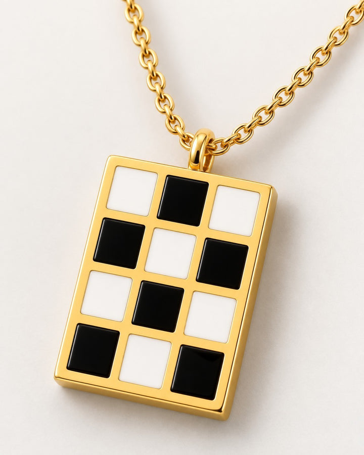 Elli Jewellery gold-plated rectangular pendant necklace featuring a black and white checkered enamel pattern.