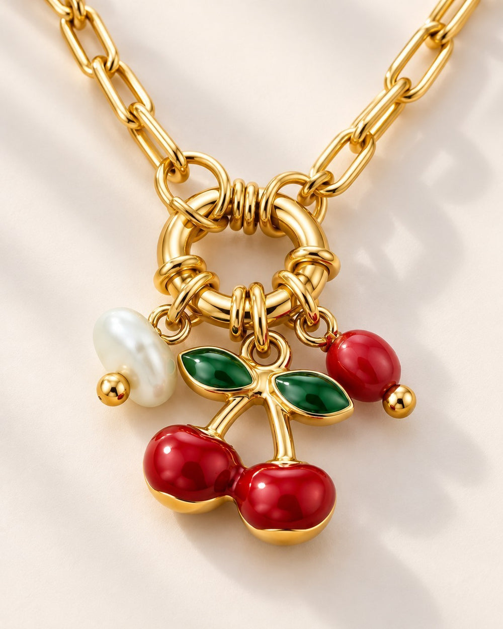 Elli Jewellery gold plated chain necklace featuring a cherry charm with red enamel, green leaves, and a white pearl.