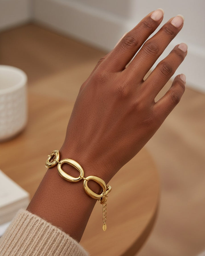 Elli Jewellery gold plated chunky chain link bracelet worn on a model's wrist, featuring large interlocking links.