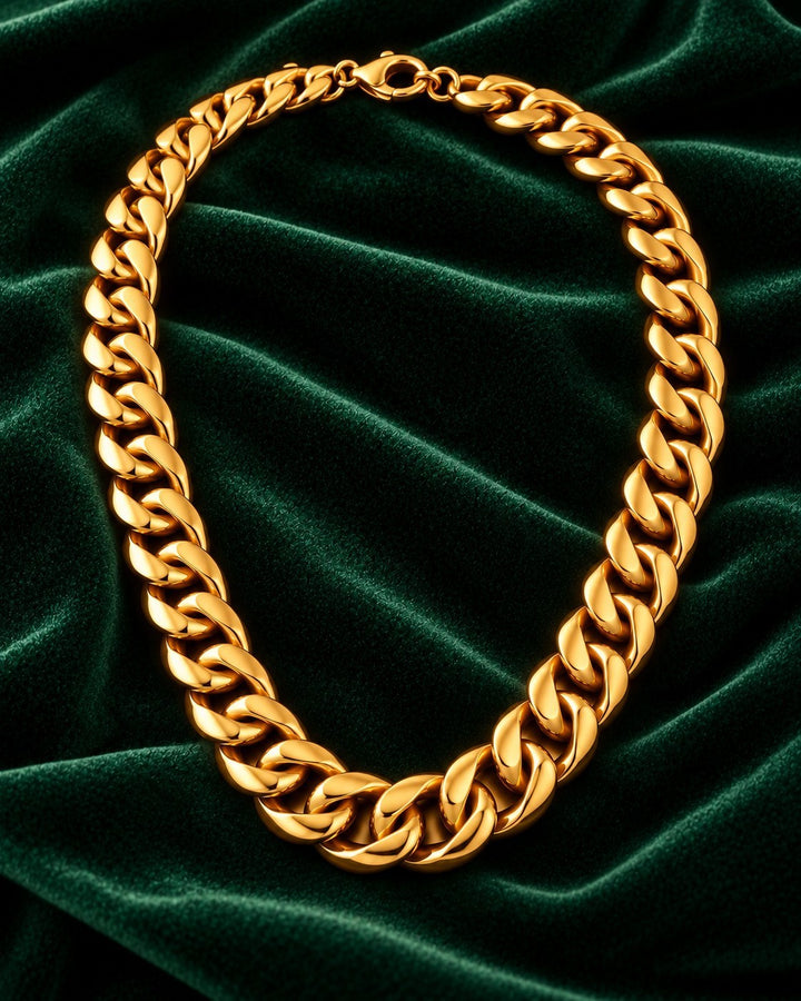 Elli Jewellery gold-plated chunky Cuban chain necklace resting on a luxurious dark green velvet background.