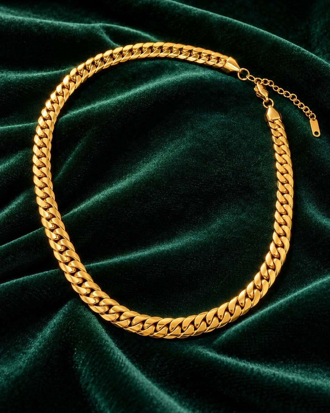 Elli Jewellery gold plated chunky curb chain necklace with a tarnish-free finish displayed on dark green velvet.