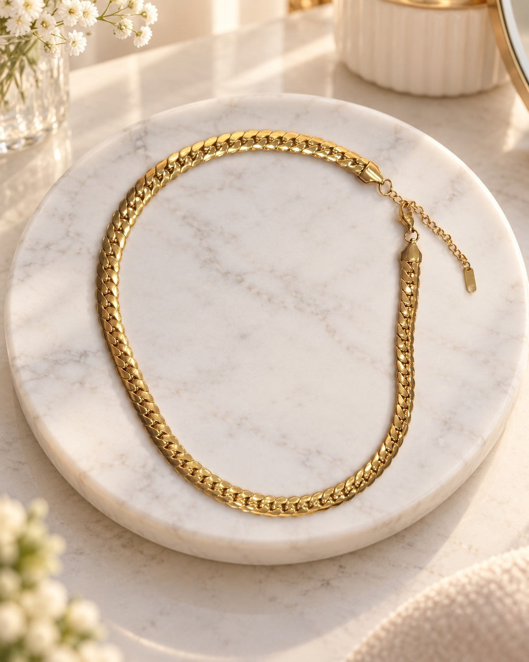 Elli Jewellery gold plated chunky curb chain necklace with a waterproof and tarnish-free finish on a marble display.