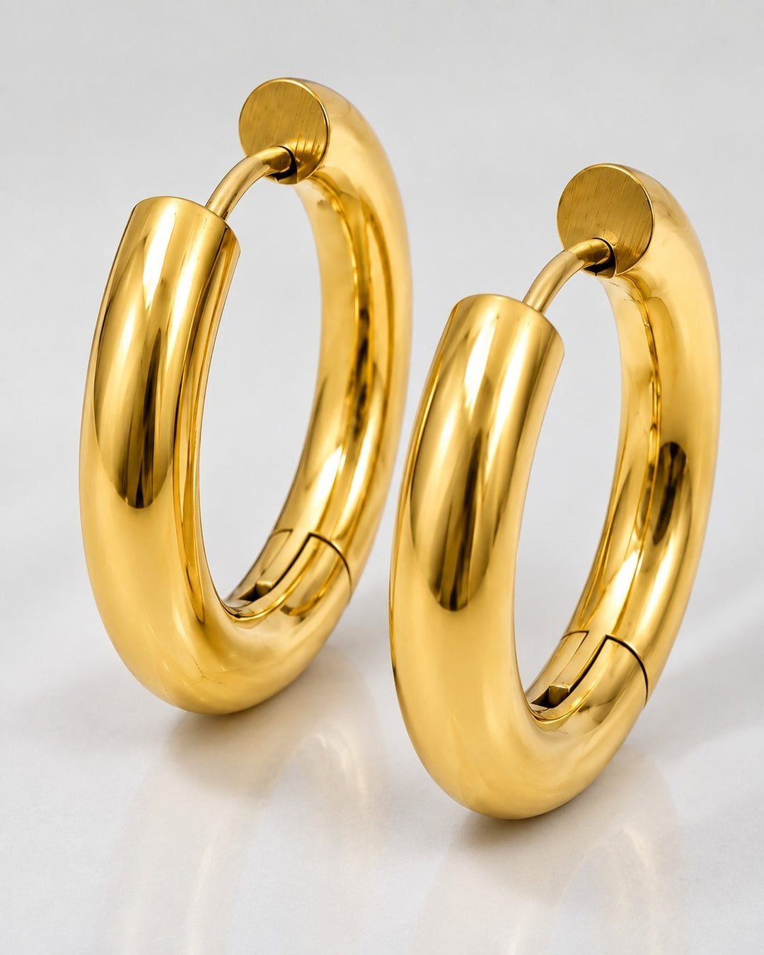 Elli Jewellery gold plated chunky huggie hoop earrings with a polished finish and secure hinged clasp