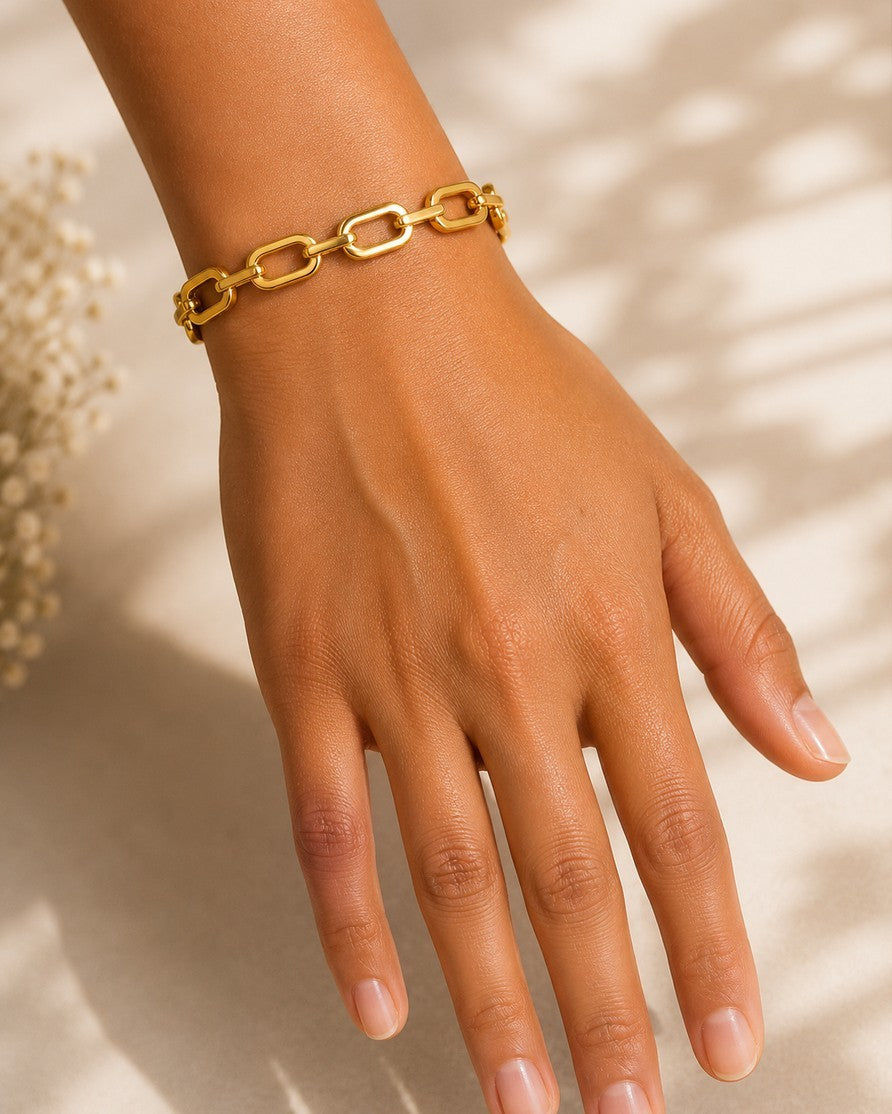 Elli Jewellery gold plated chunky link chain cuff bangle worn on a woman's wrist against a neutral background.