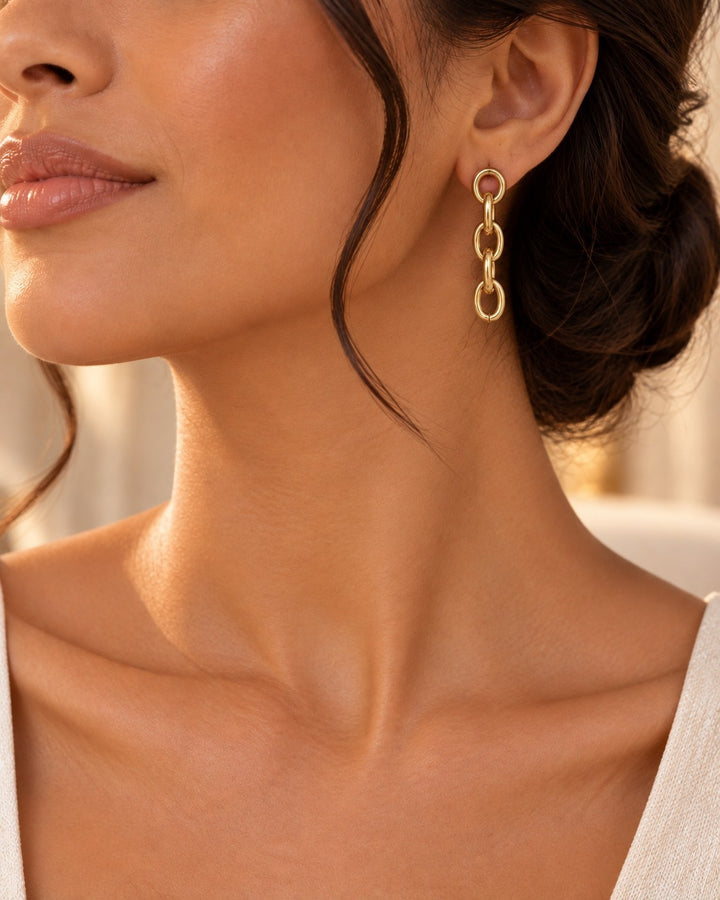 Elli Jewellery gold plated waterproof chunky link chain drop earrings worn by a woman with an elegant updo