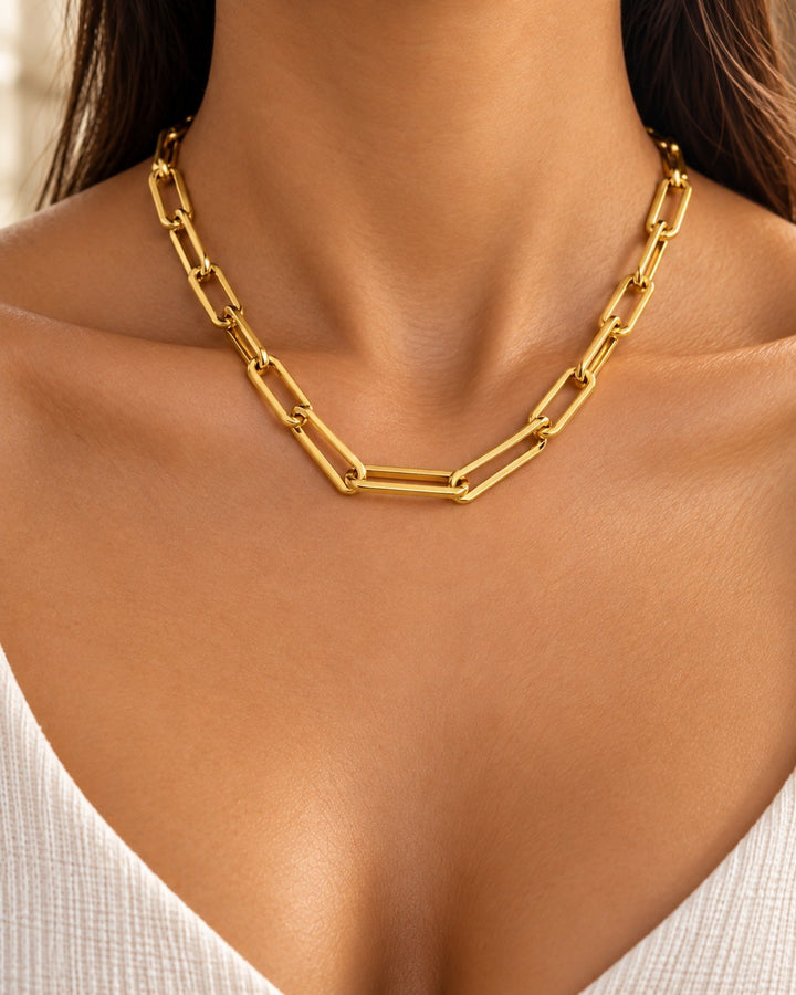 Elli Jewellery gold plated chunky paper link chain necklace worn on a model with a white top