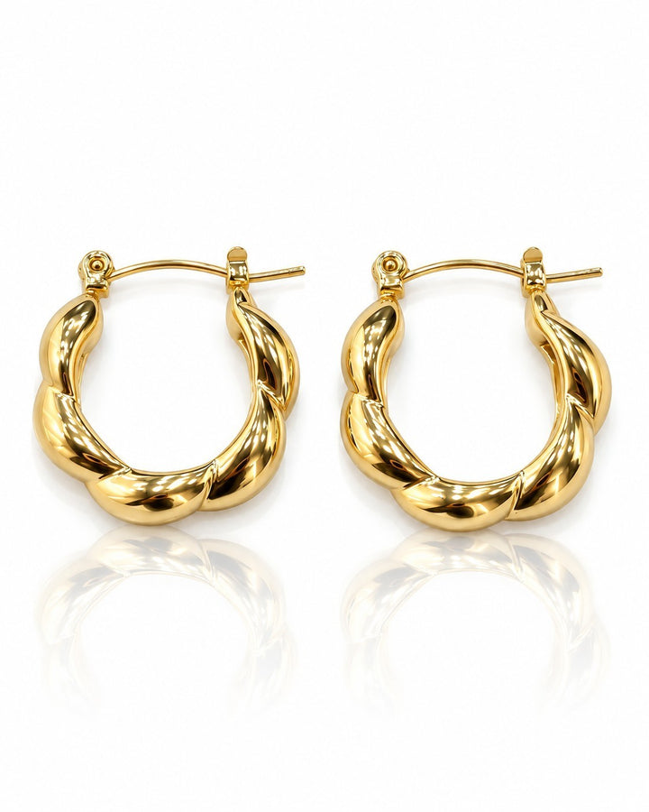 Elli Jewellery gold plated chunky geometric hoop earrings with a twisted sculptural design on a white background.