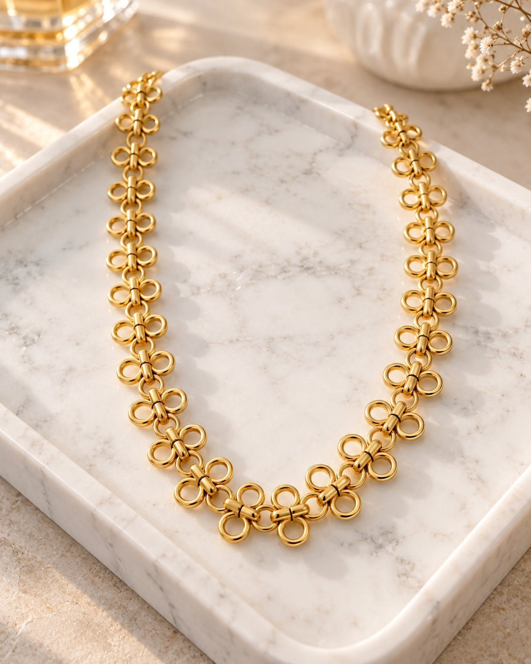 Elli Jewellery gold plated waterproof necklace featuring interlocking circle links displayed on a marble tray.