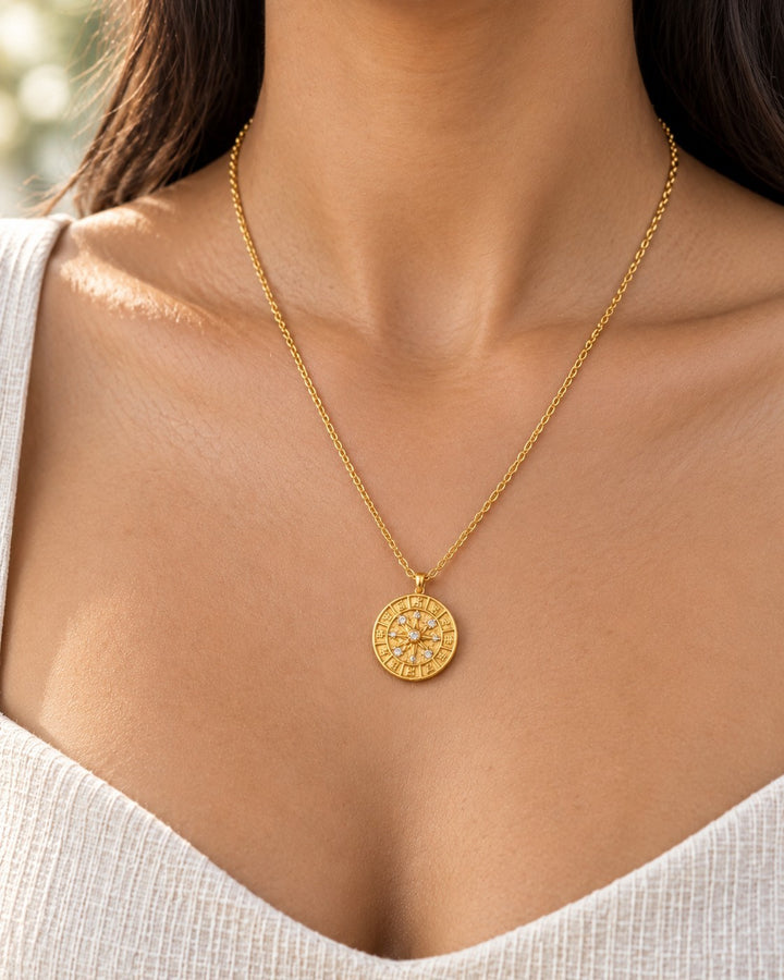 Elli Jewellery gold plated celestial compass coin pendant necklace worn on a model with a delicate chain