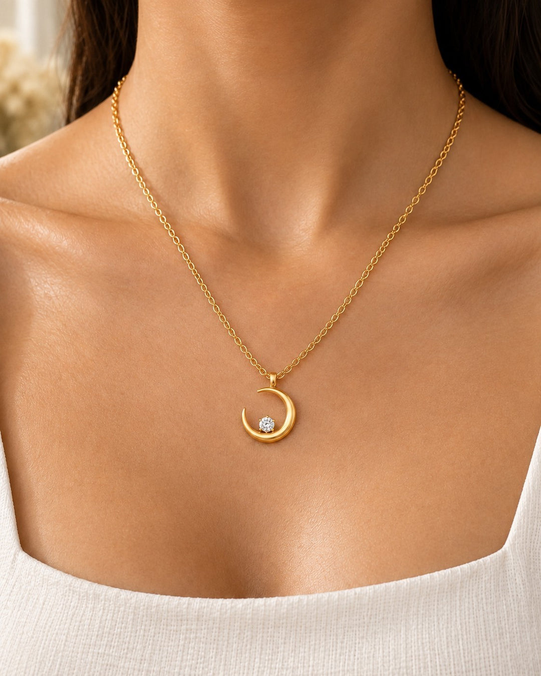 Elli Jewellery gold plated crescent moon pendant necklace with a central sparkling stone worn on a delicate chain