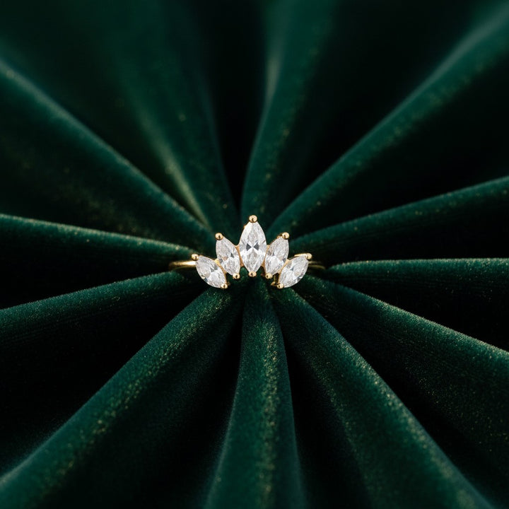 Elli Jewellery gold plated crown ring with marquise-cut stones on a dark green velvet background