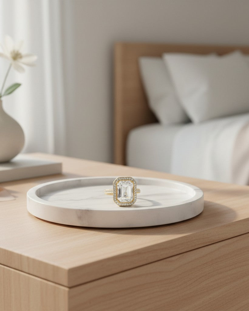 Elli Jewellery gold plated chunky ring with a large rectangular clear crystal on a white marble tray.